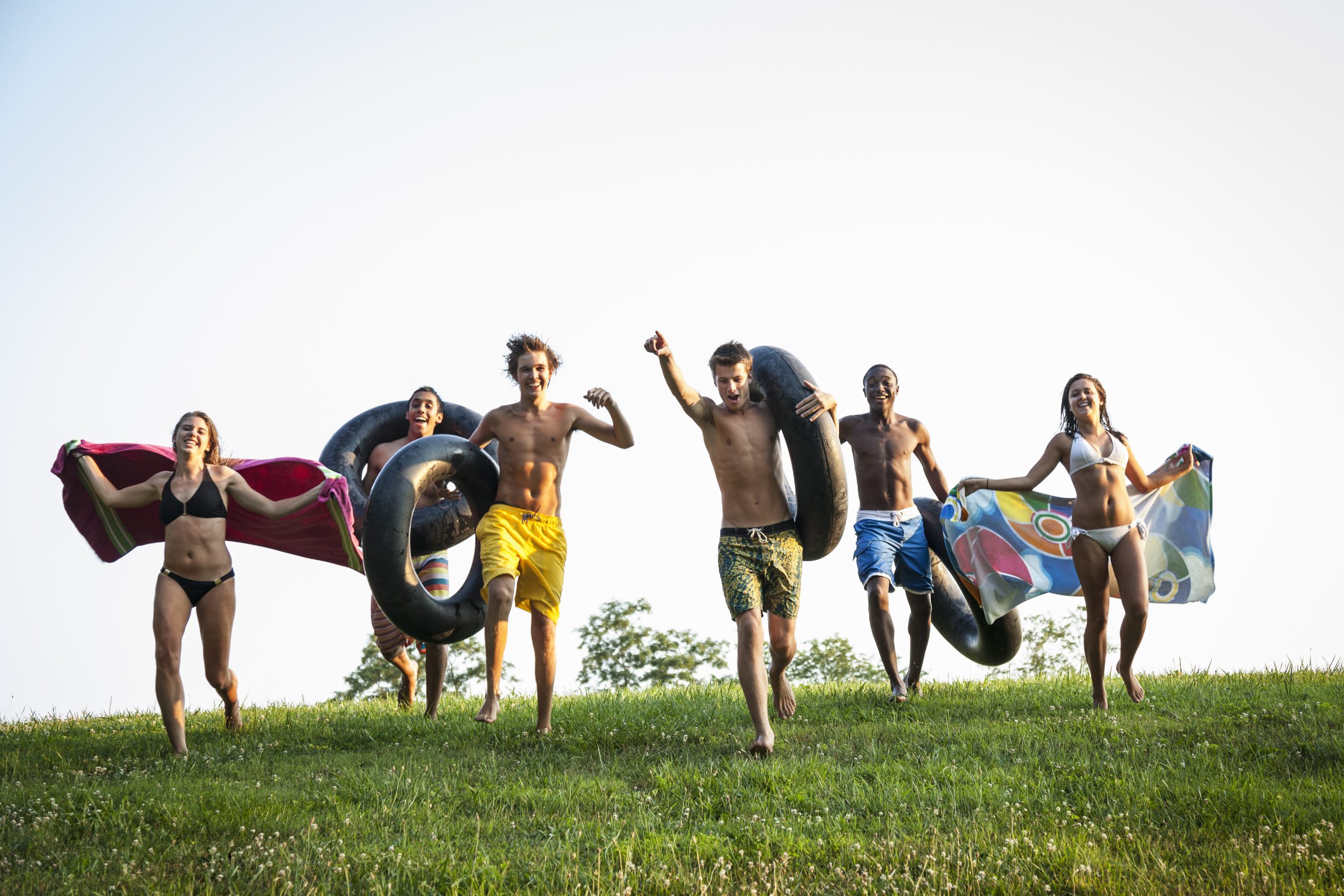 a-group-of-teenagers-running-across-grass-holding-2022-03-04-02-40-40-utc-min